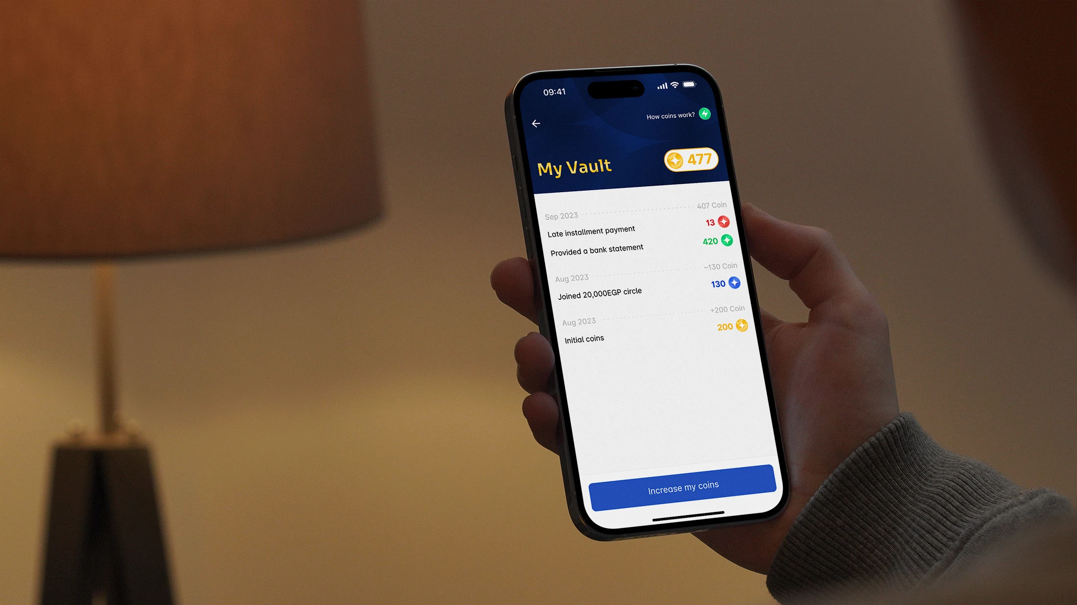 My Vault screen on a phone held in hand — the coin ledger showing earned, deducted and used entries